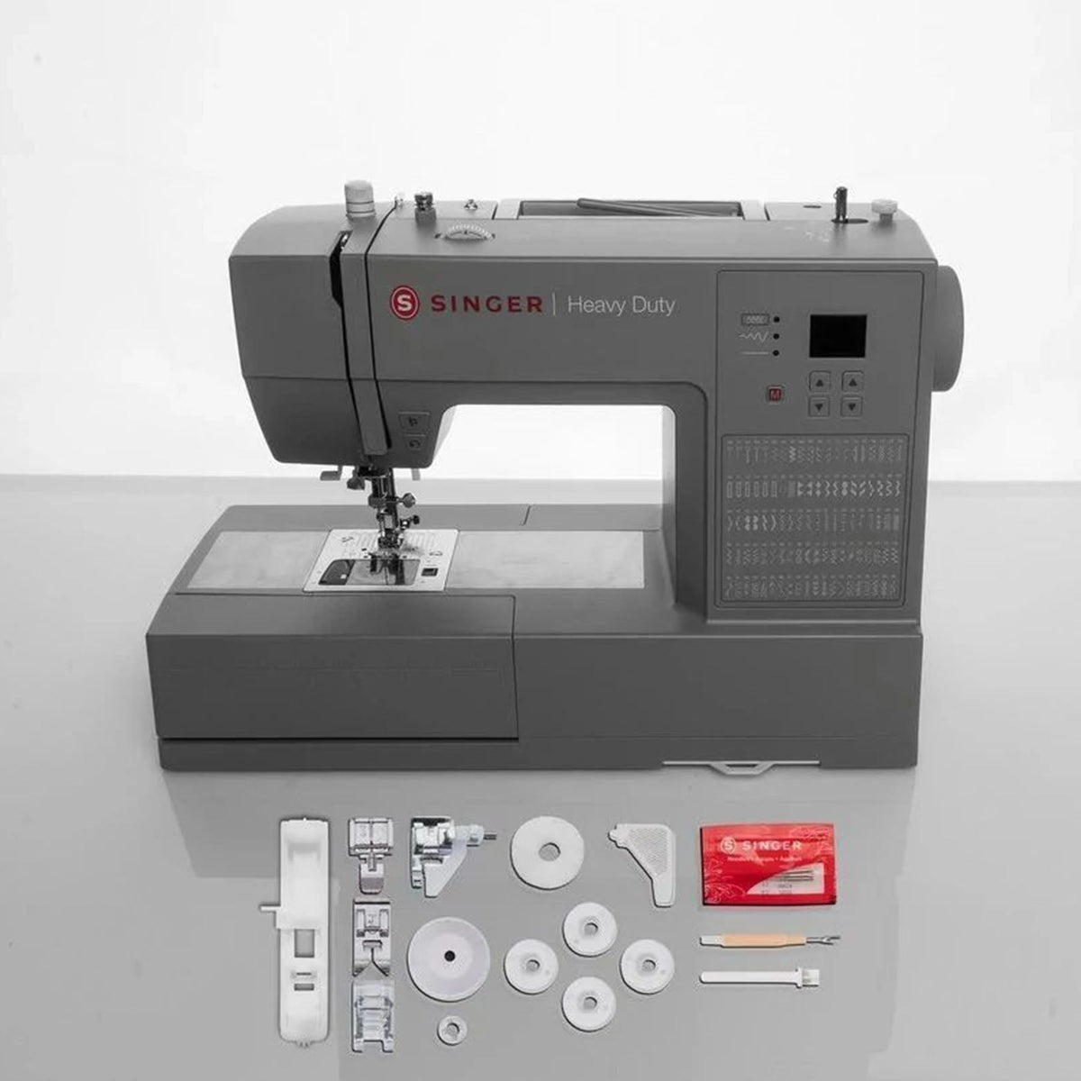Singer Heavy Duty 6600C with its included presser feet, bobbins, and accessories laid out in front