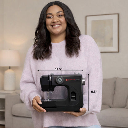 Singer M1000 Black mending machine held in two hands
