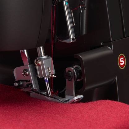 Close-up of the Singer HD0500S needle and presser foot on thick red fabric
