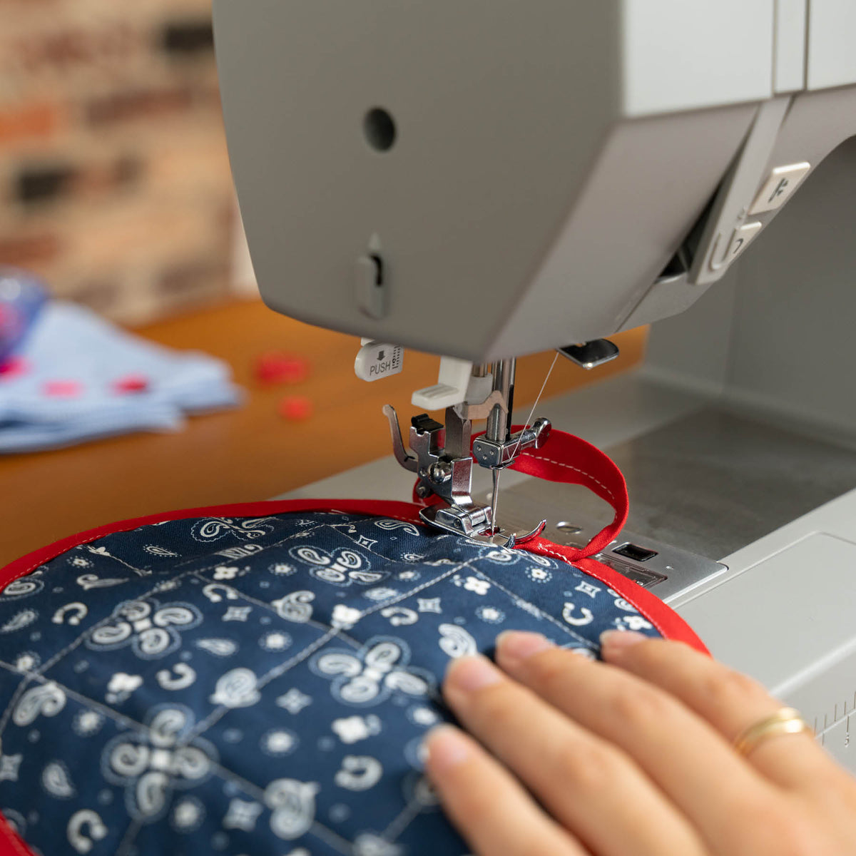 Singer Heavy Duty 6600C sewing navy patterned fabric with red binding, close view of the presser foot
