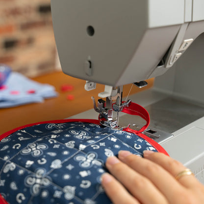 Singer Heavy Duty 6600C sewing navy patterned fabric with red binding, close view of the presser foot