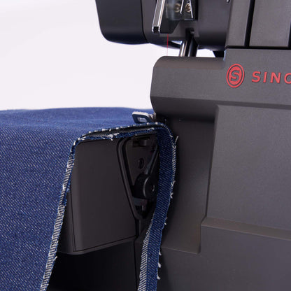 Singer HD0460 serger close-up with blue denim fabric draped over the front of the machine