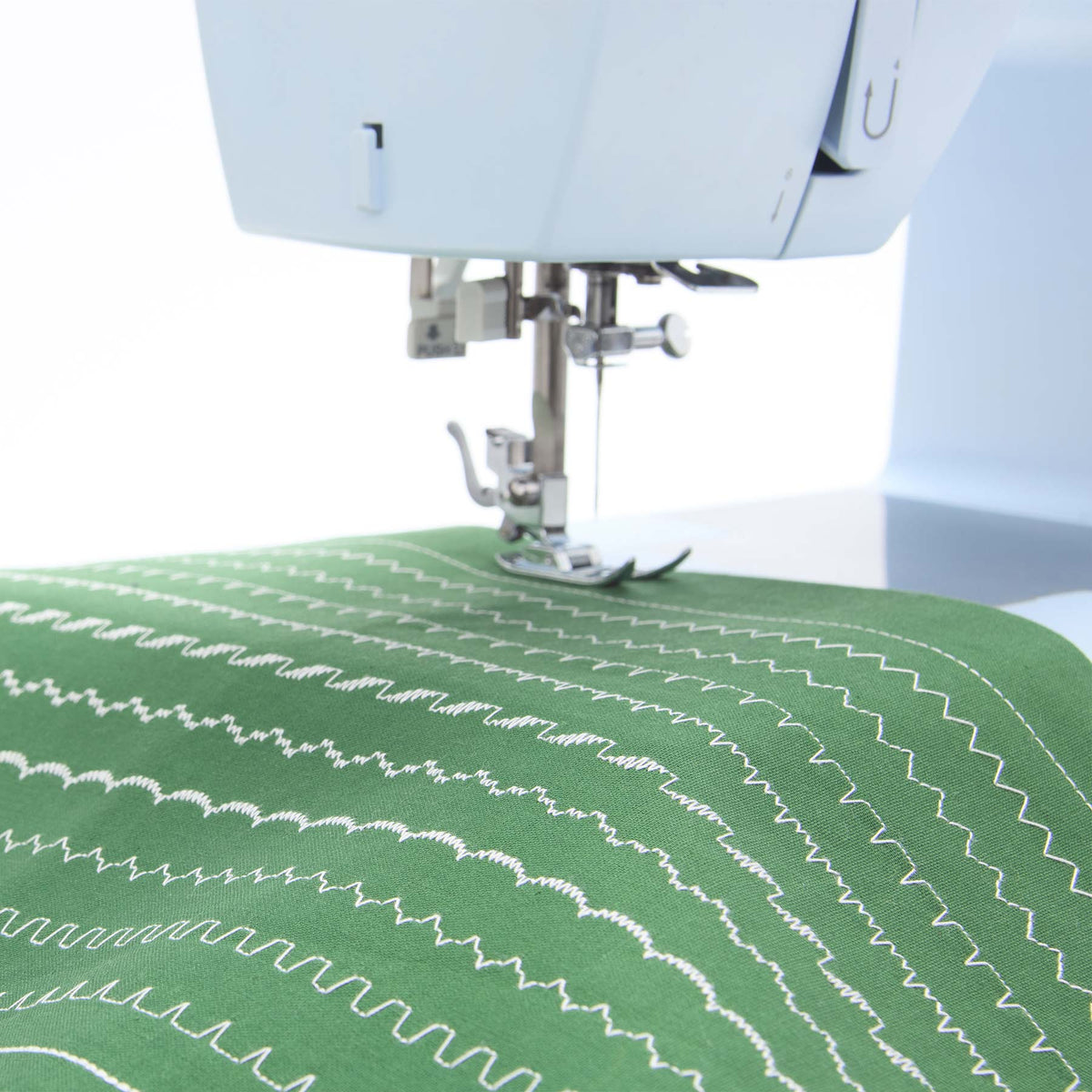 Singer Heavy Duty 4423 presser foot over rows of decorative stitches on green fabric