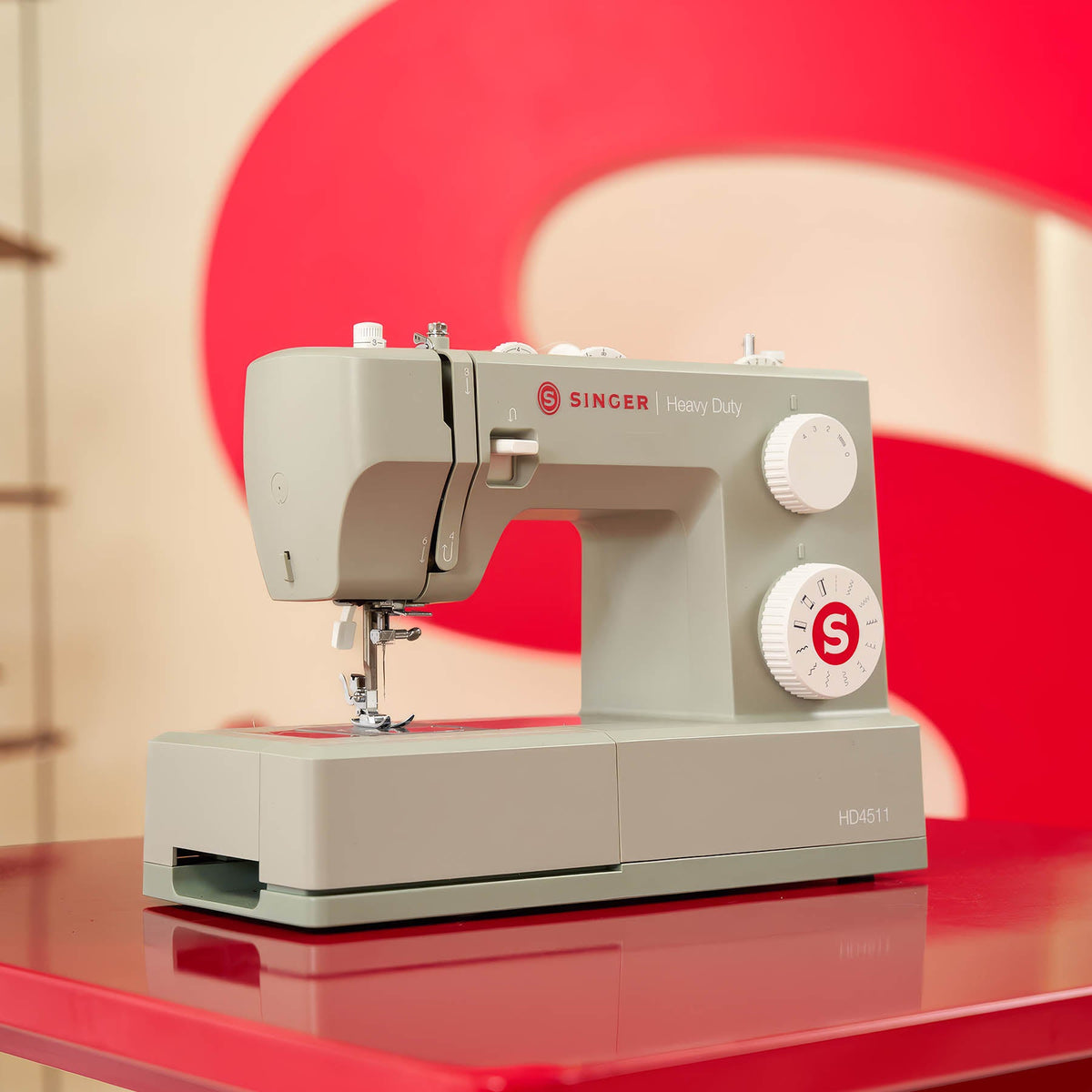 Singer Heavy Duty 4511 Sage on a red table, angled view