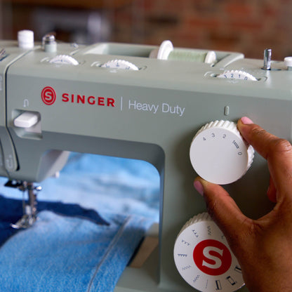 Hand turning the dial on the Singer Heavy Duty 4511 Sage