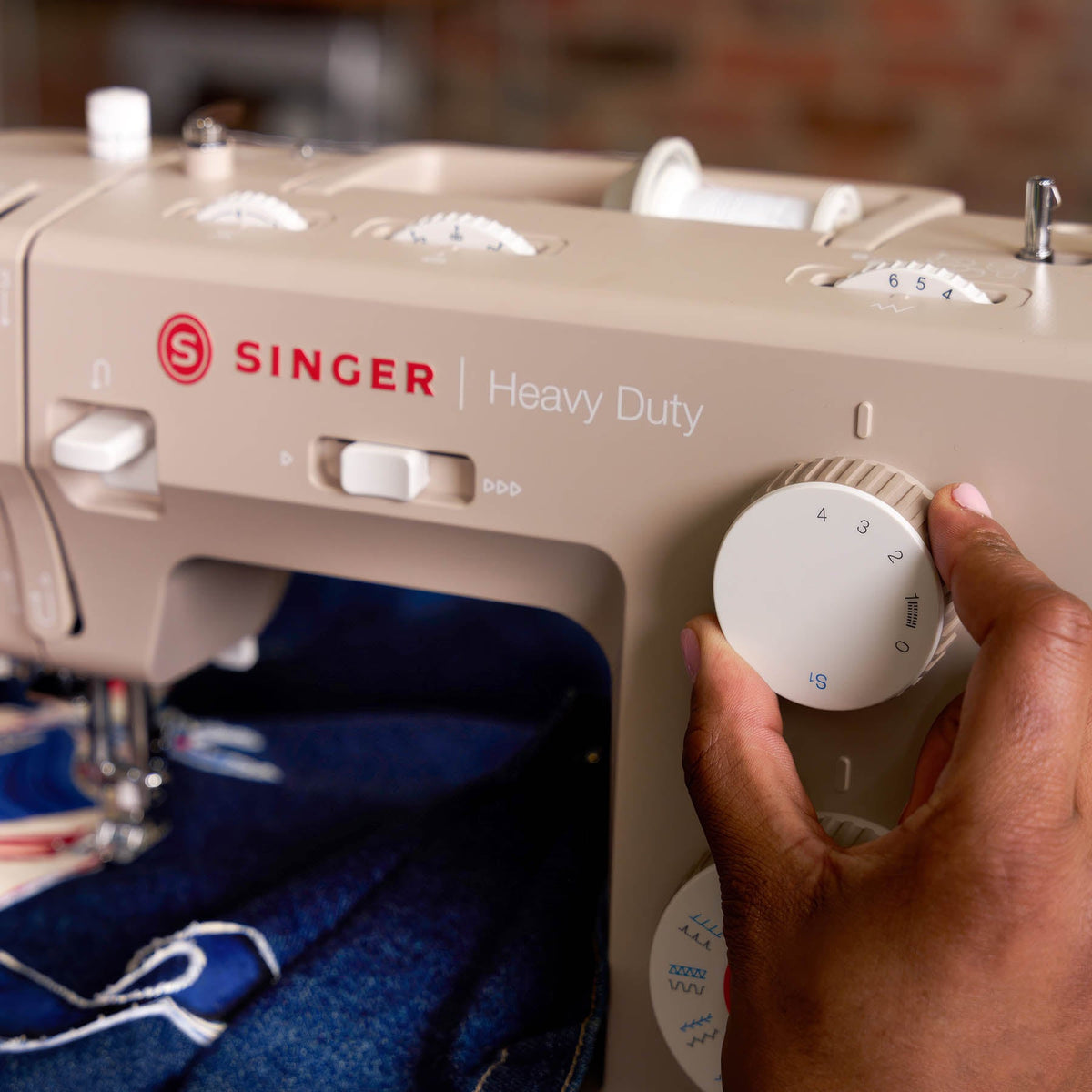 Hand turning the textured stitch length dial on the Singer Heavy Duty 4523