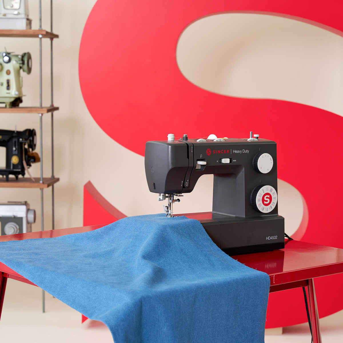 Singer Heavy Duty 4532 on a table with light blue denim fabric, seen from the side