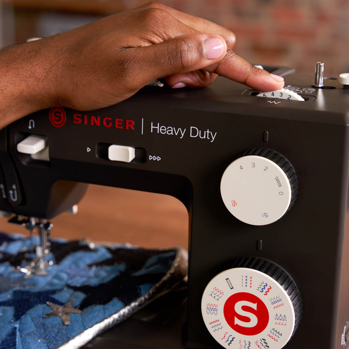 Finger on the top dial of the Singer Heavy Duty 4532