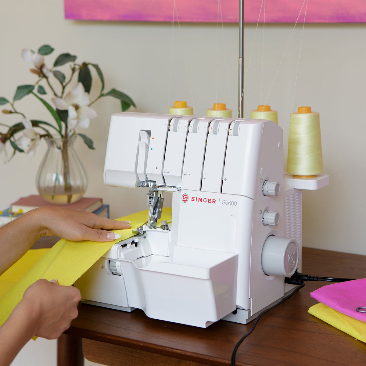 Singer S0600 serger in use with yellow fabric at a table