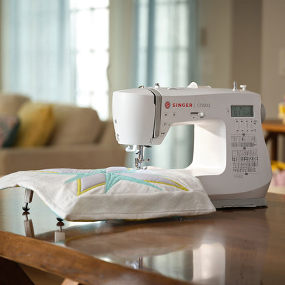 Singer C7290Q sewing machine with extension table supporting a quilt block