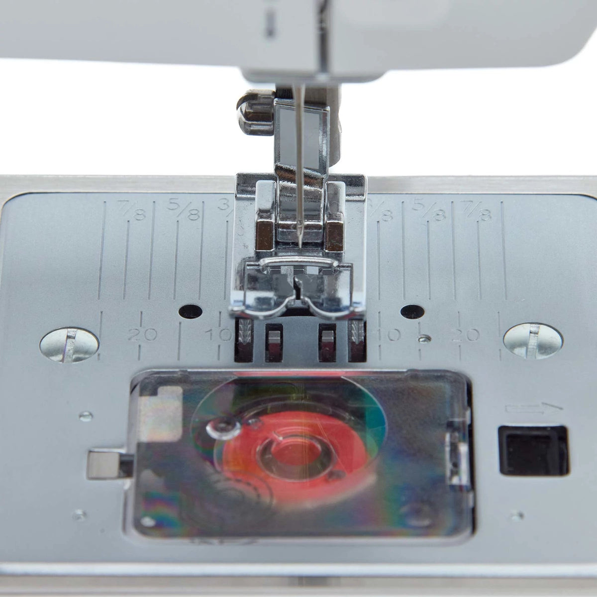Singer Prisma Heavy Duty needle plate with the transparent bobbin cover over a red bobbin