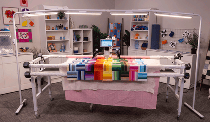 Finesse Aura light bar over a longarm quilting frame in a studio