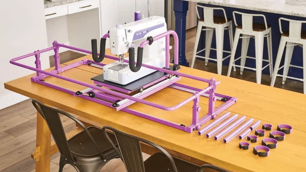 Handi Quilter FreeWay frame set up on a dining table with rollers and clamps alongside